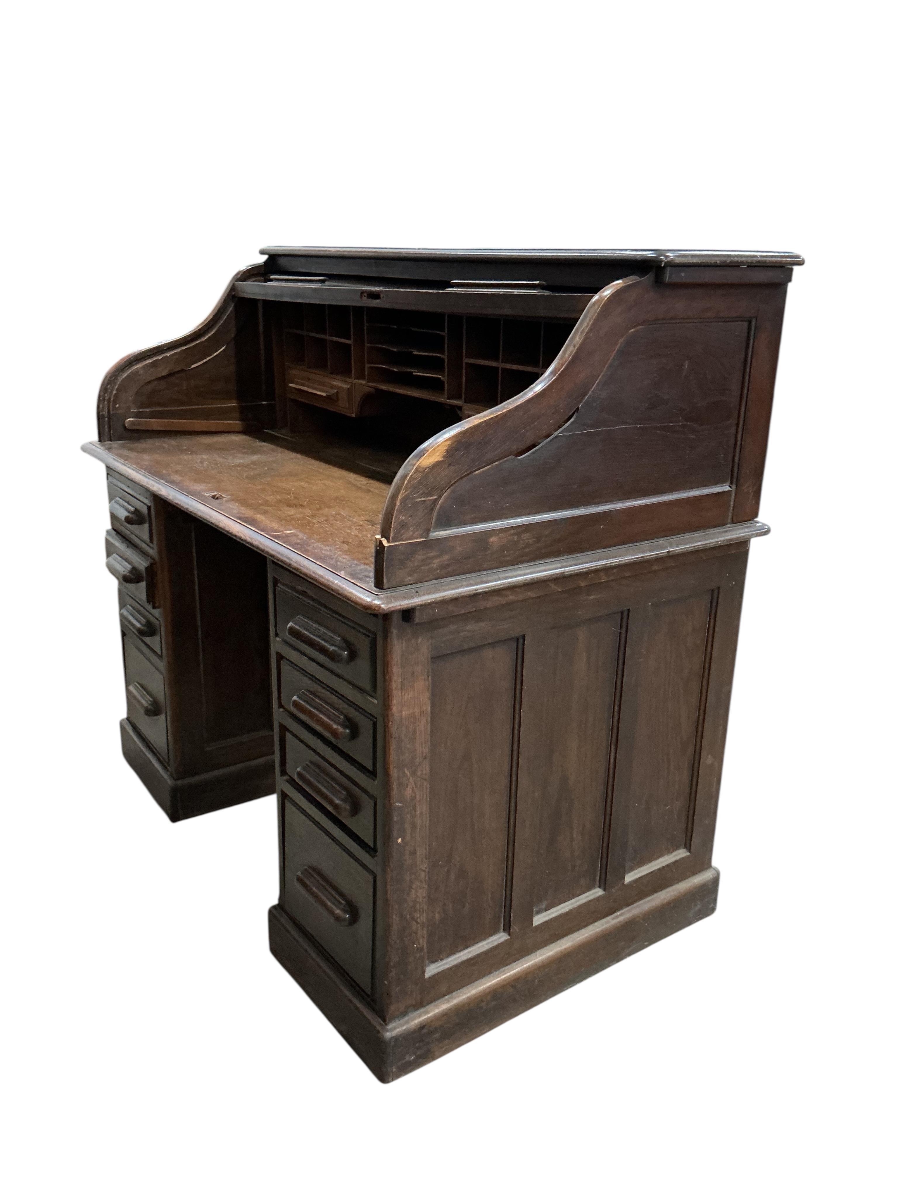 An early 20th century oak 'S' shaped tambour roll top desk, width 124cm, depth 78cm, height 120cm